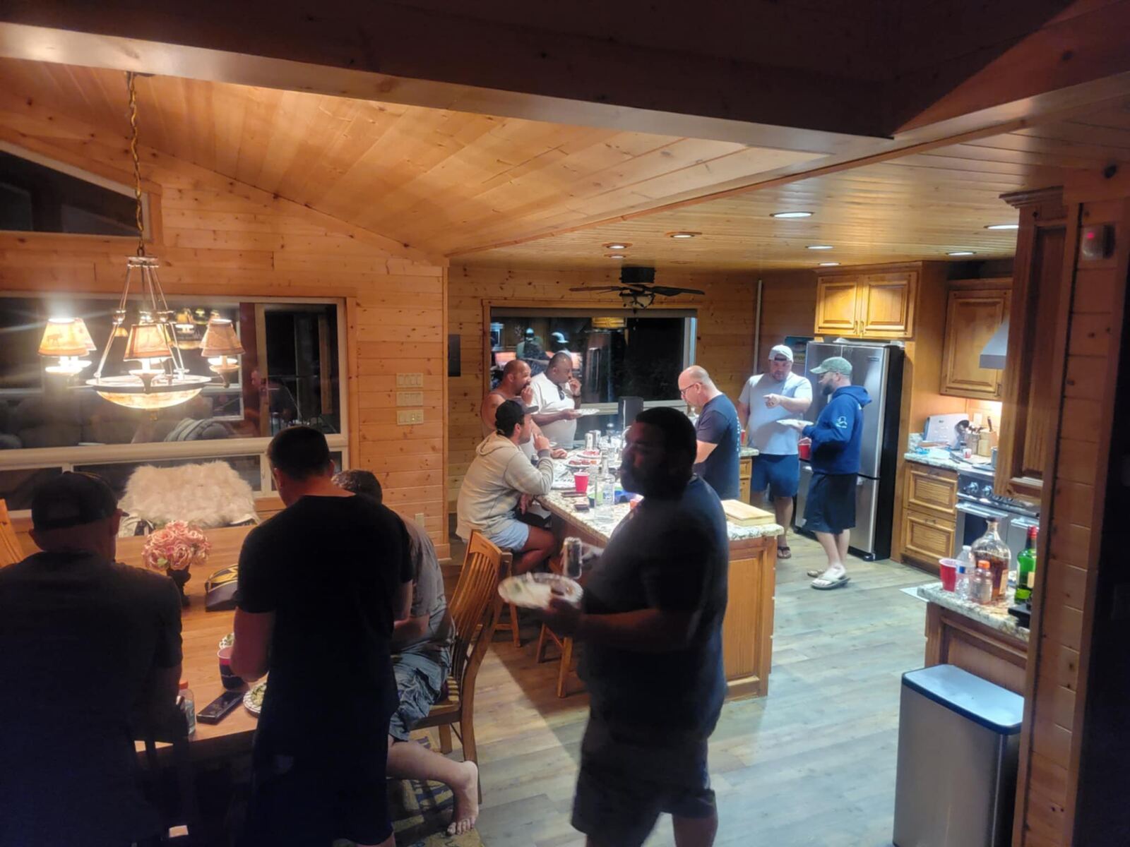 Cabin kitchen full of brothers, plates moving, cold beers out