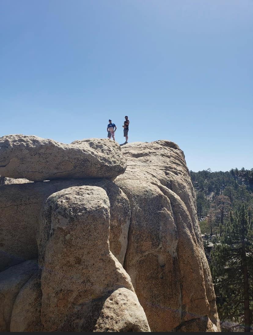 Two silhouettes on the granite cliff under a clean blue sky