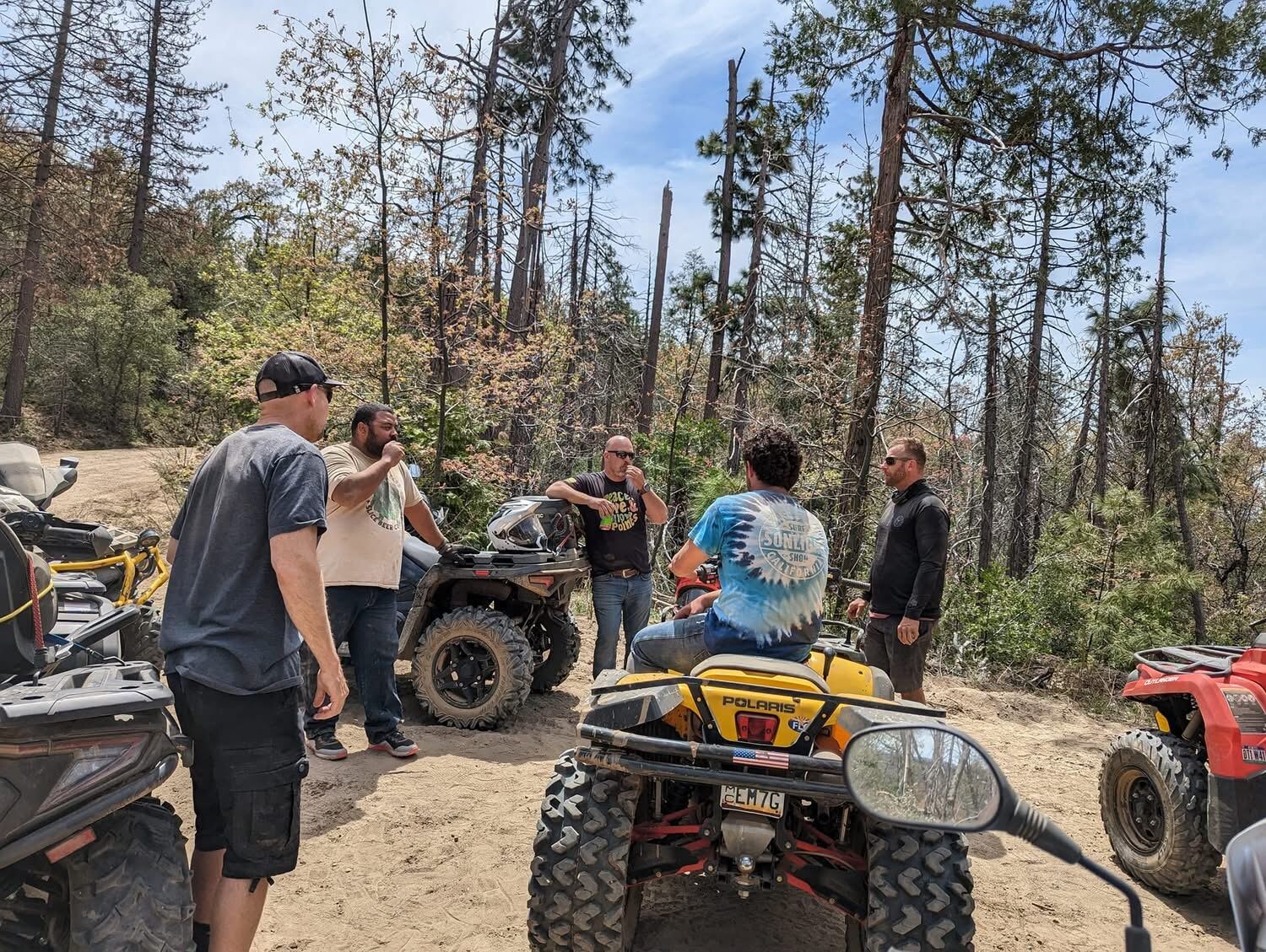 ATV stop on the dirt trail — tie-dye and dust in the pines