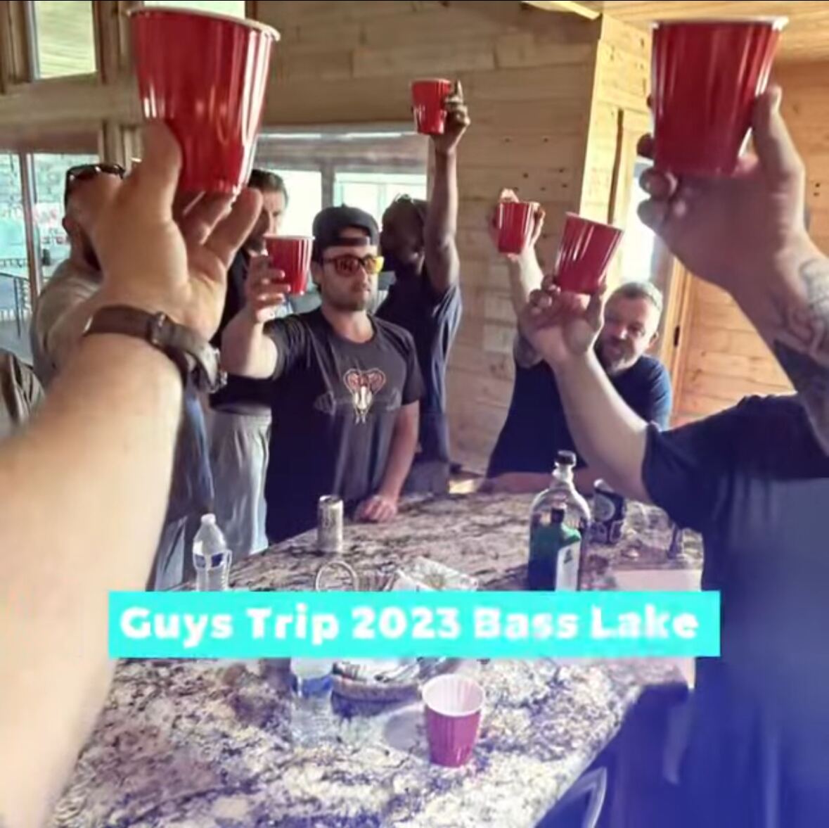 Guys Trip 2023 Bass Lake — red Solo cups raised over the cabin counter