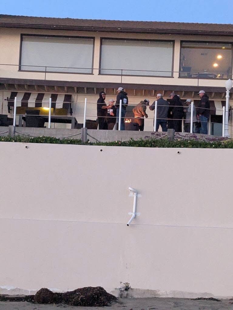 Brothers gathered on the beach-house deck at golden hour