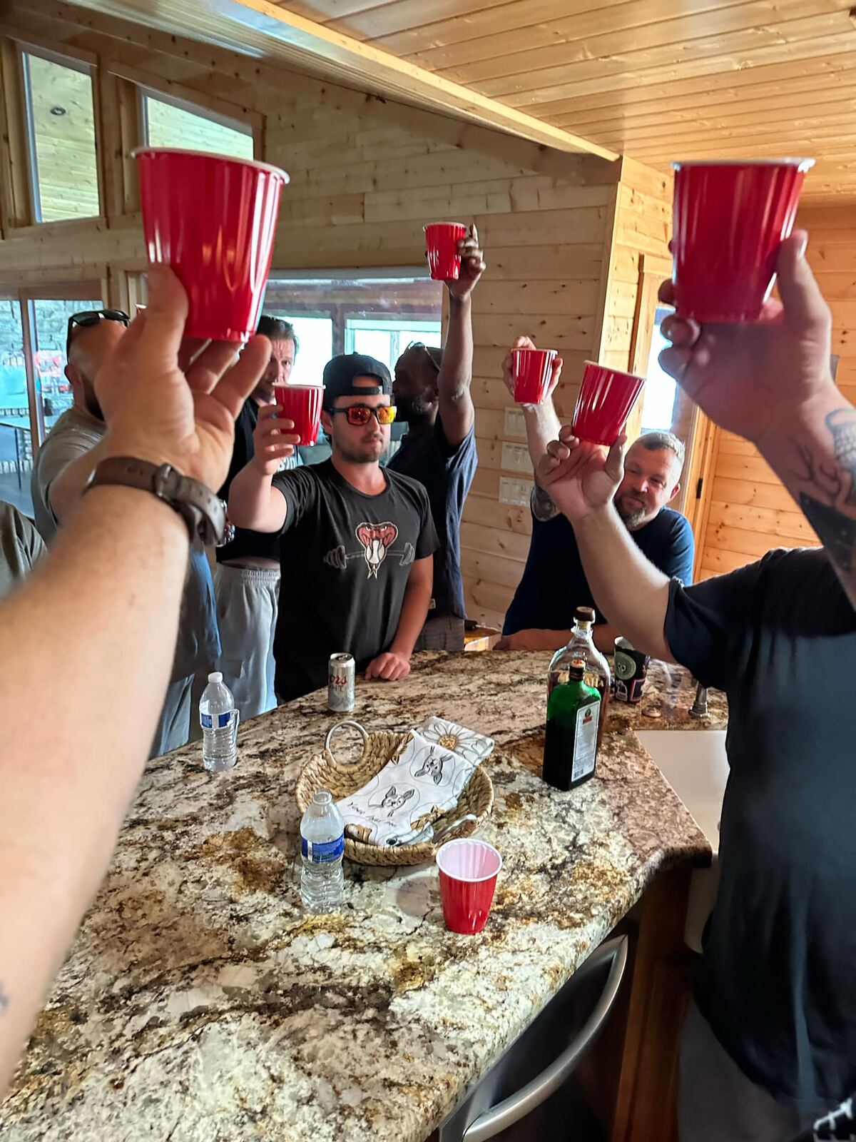 Cabin cheers — six red cups raised over the granite, Jäger on the counter