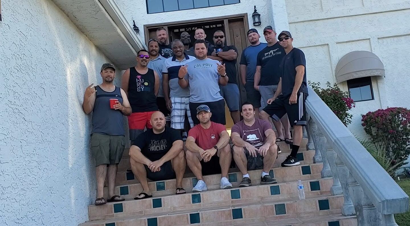 Whole crew on the front-door steps — Cal Poly tee in the middle