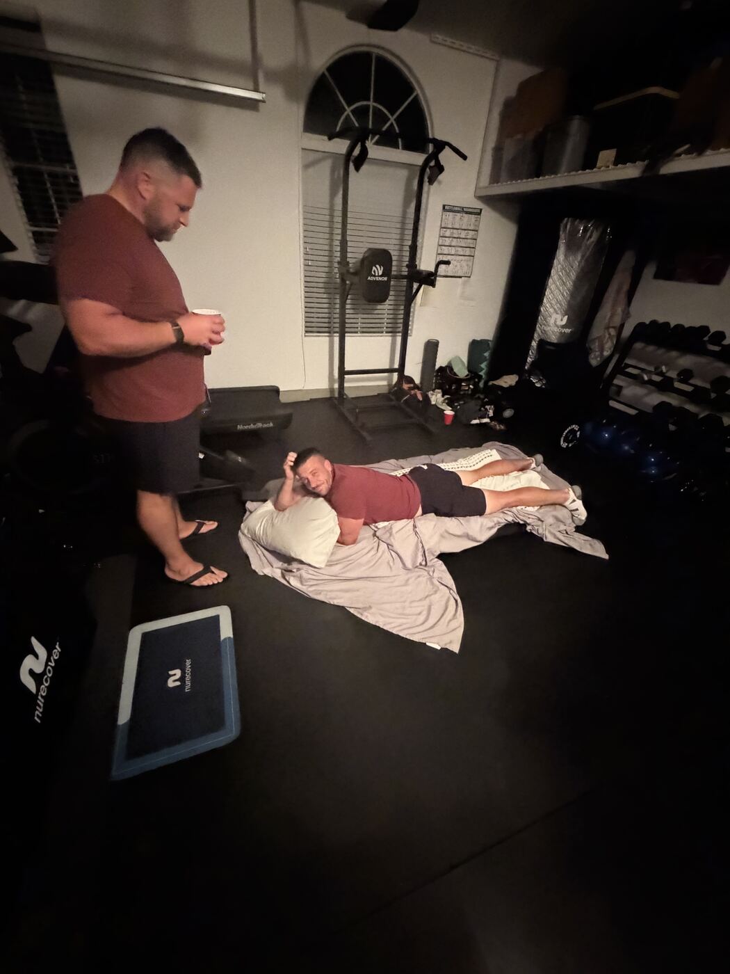 Down for the count on the gym floor — brother bringing the recovery drink