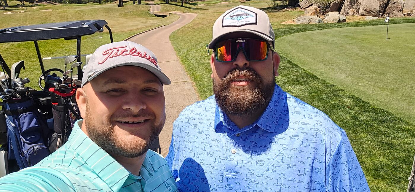 Cart selfie before the next hole — Titleist cap and Guys Trip lid
