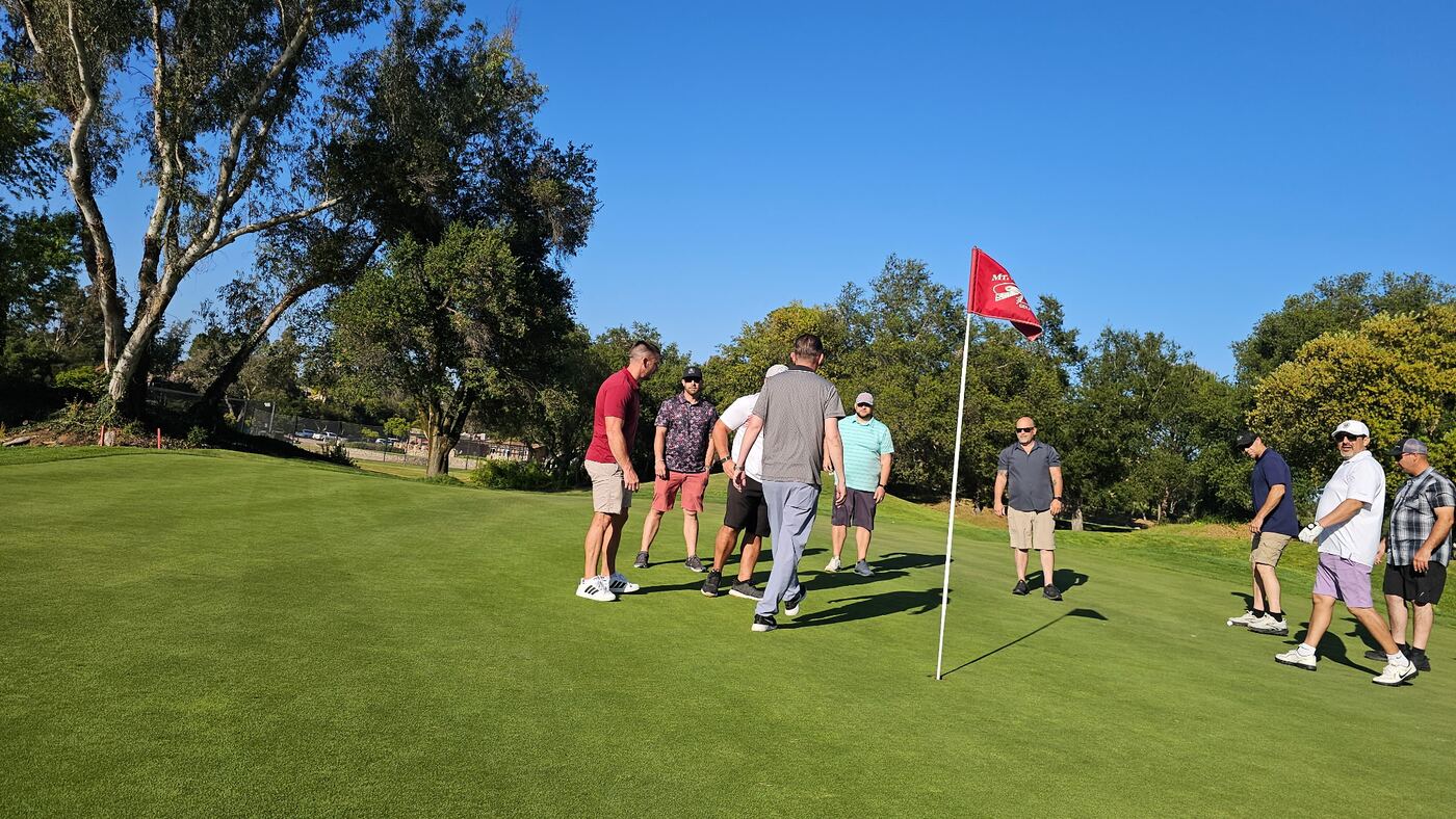 Walking up to the pin at the Jones — full crew on the green