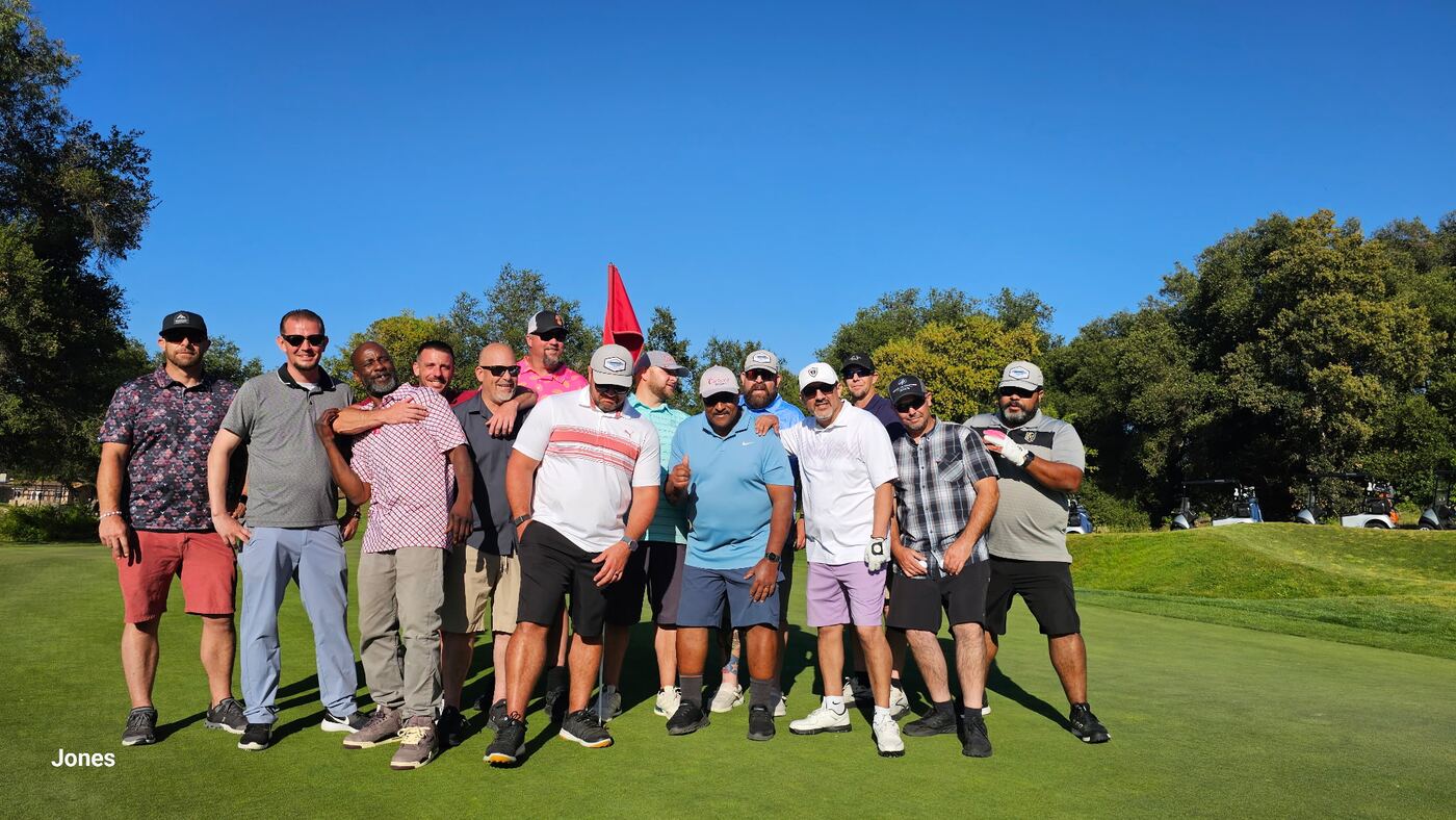 Whole crew on the green at the Jones — second angle, full lineup
