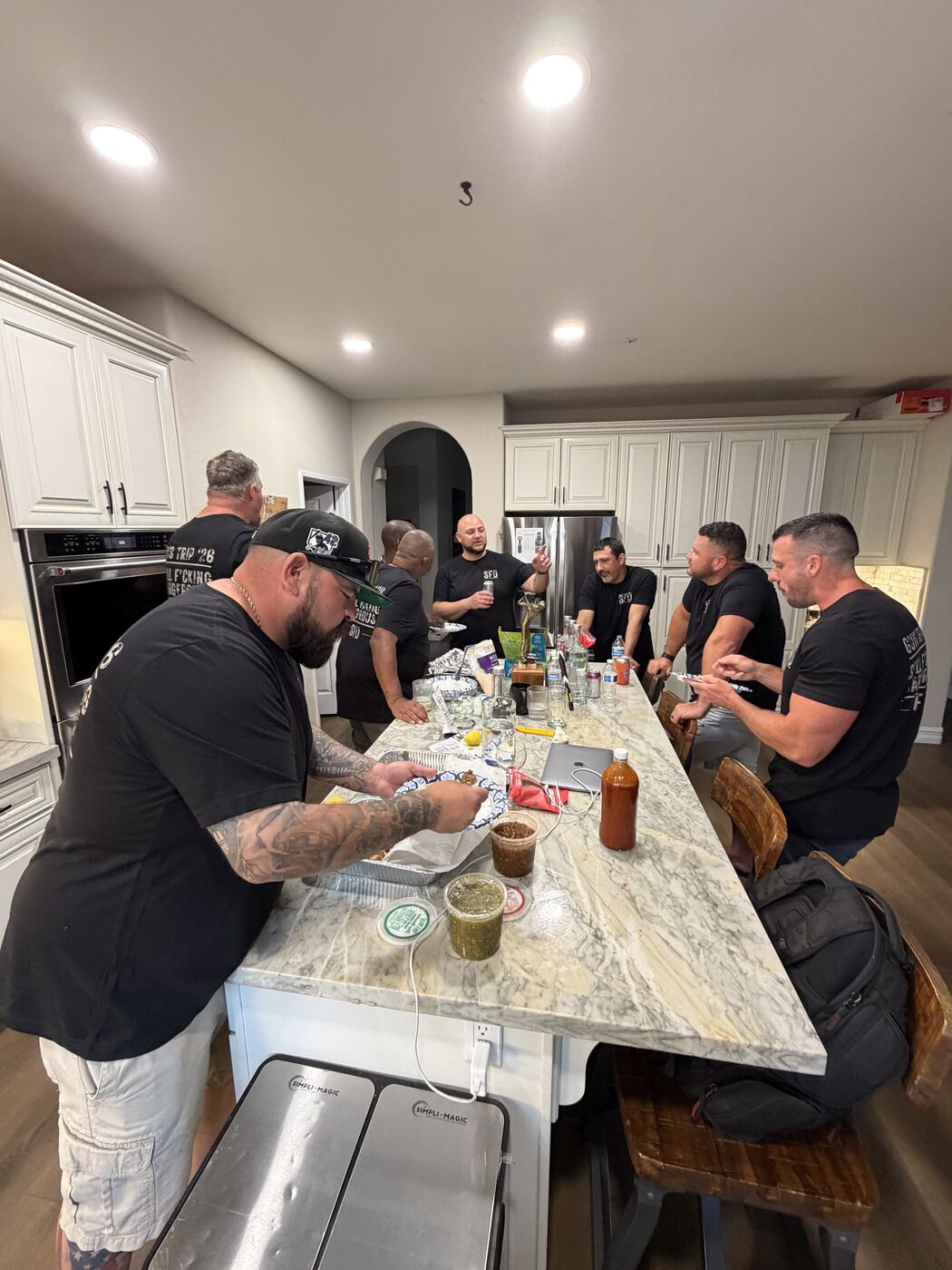 Marble island full of brothers cooking — salsa, snacks, and the Champions trophy on deck
