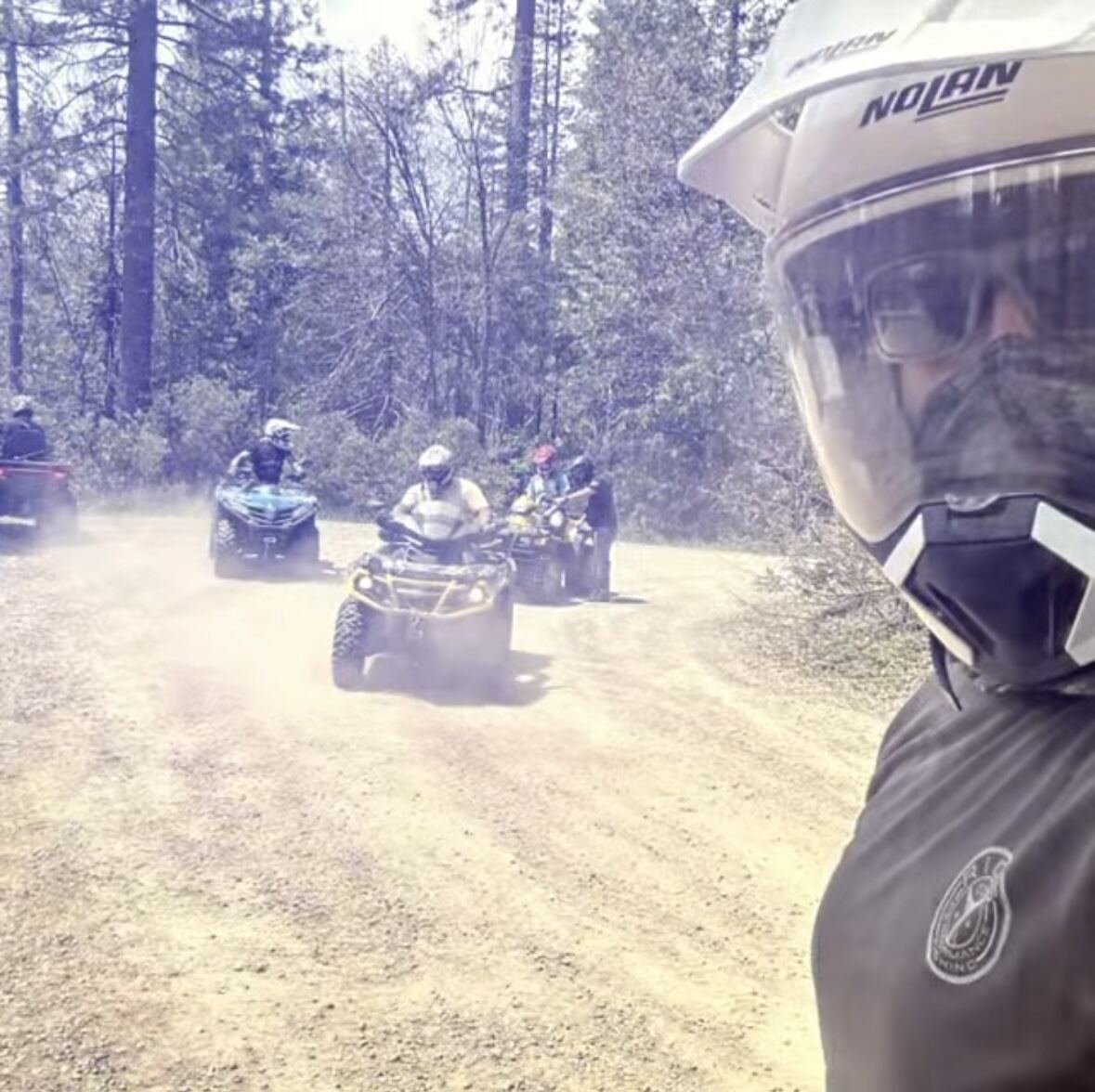 Nolan helmet selfie with the convoy kicking up dust behind