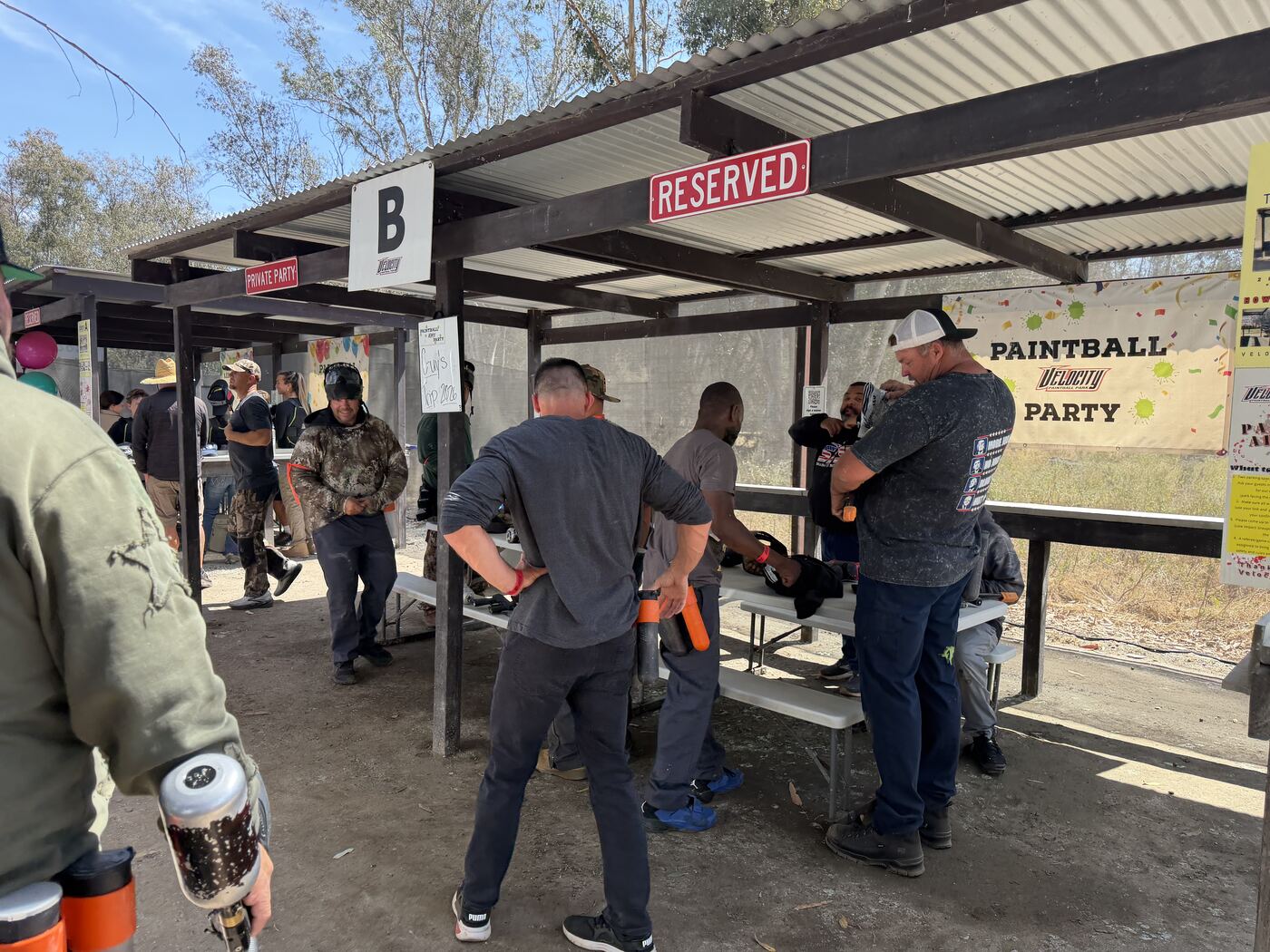 Strapping in at the picnic tables — Reserved field, full crew