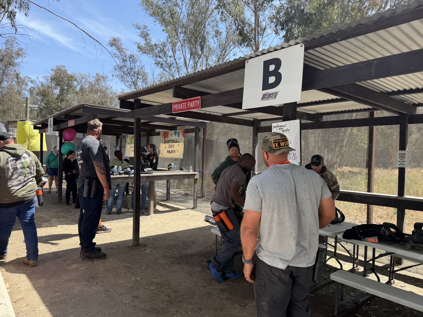 Table B at the paintball park — masks down, markers up