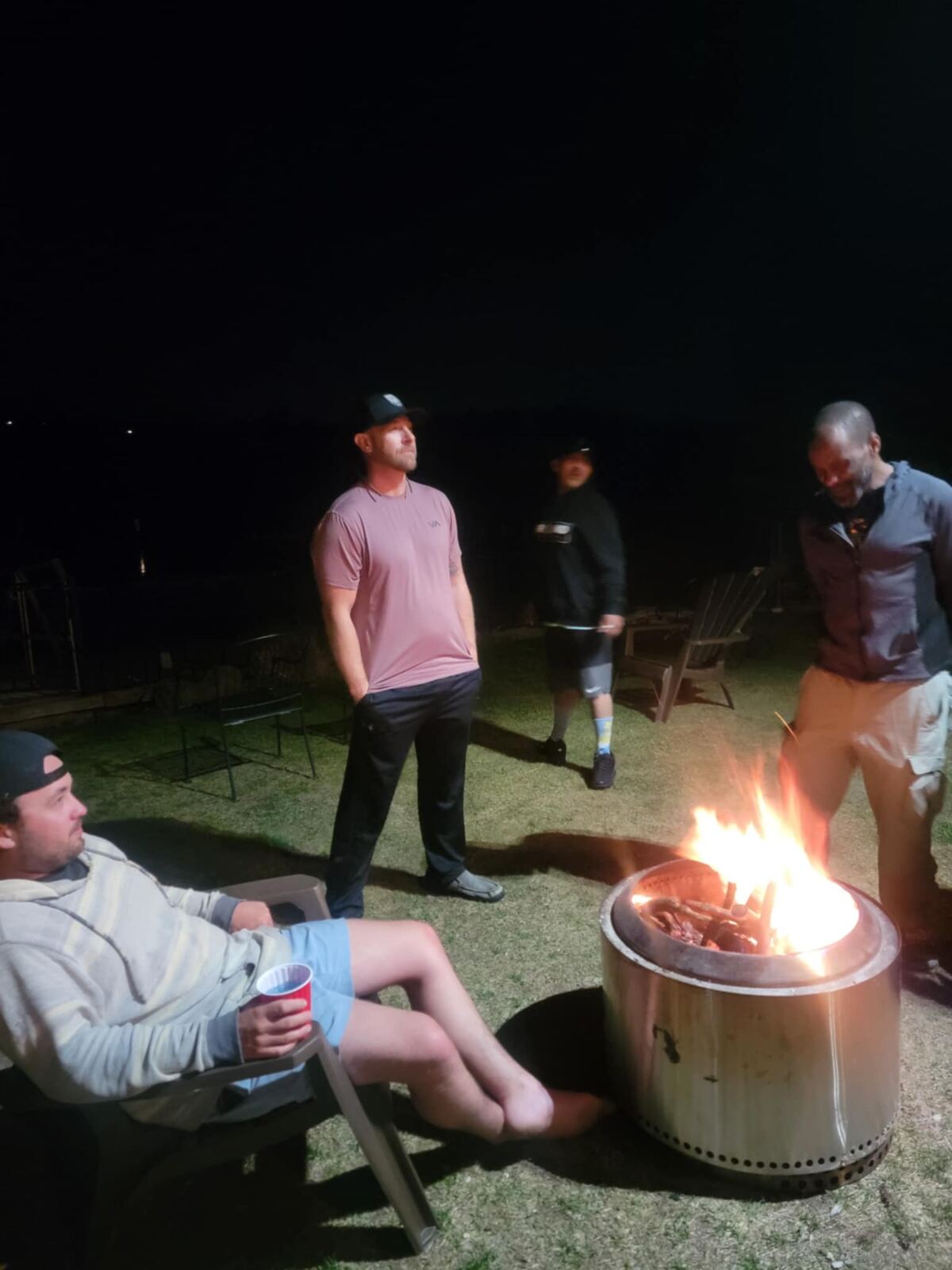 Late-night fire pit, red cup in hand