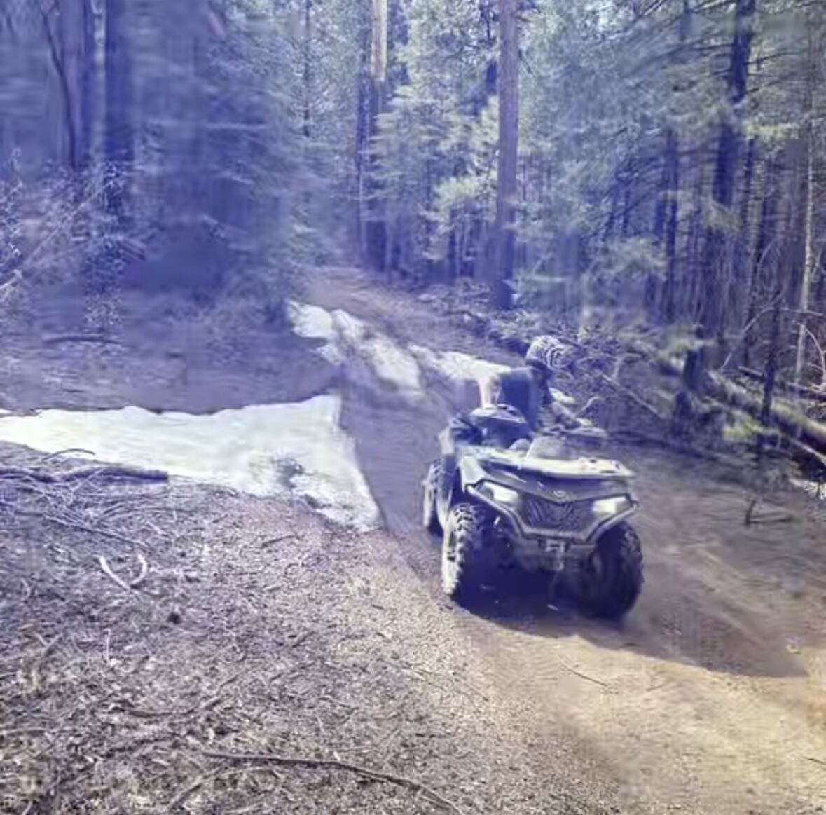 Snowmelt water crossing on the trail — quad pushing through the runoff
