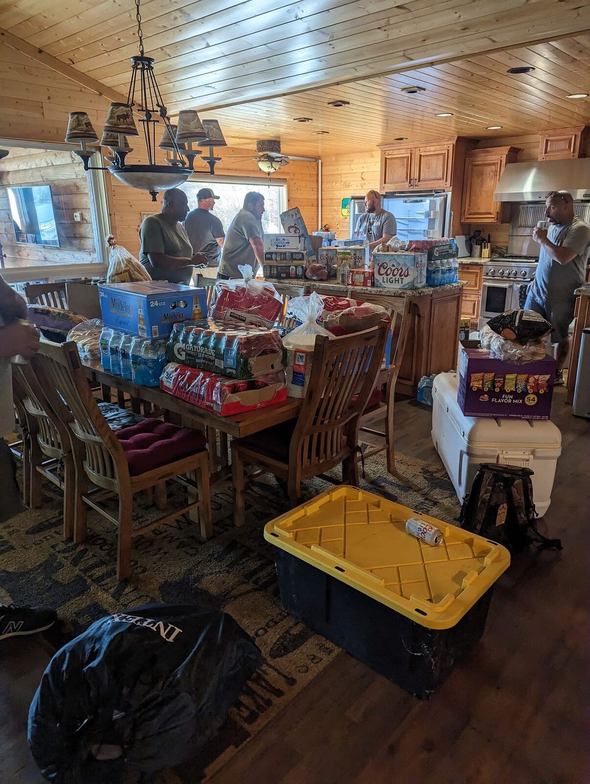 Supply run unloading at the cabin — Modelo, Coors, ice and ammo cans