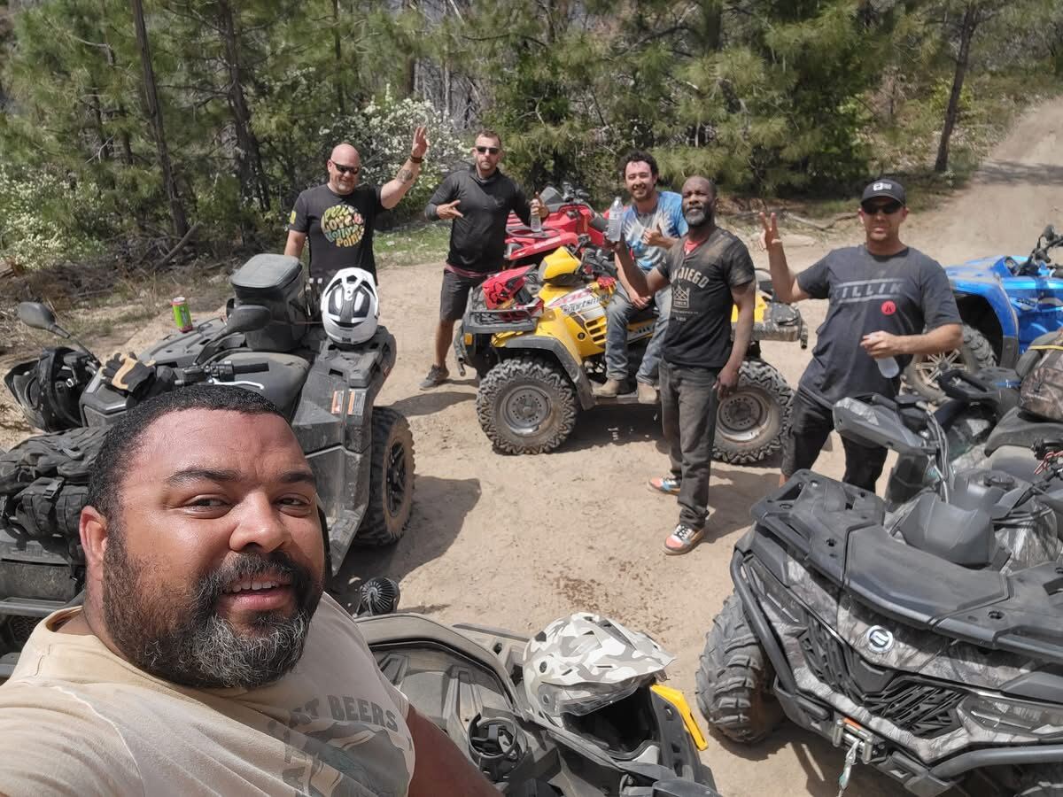 Trailhead selfie — six brothers in the pines around the quads, peace signs up