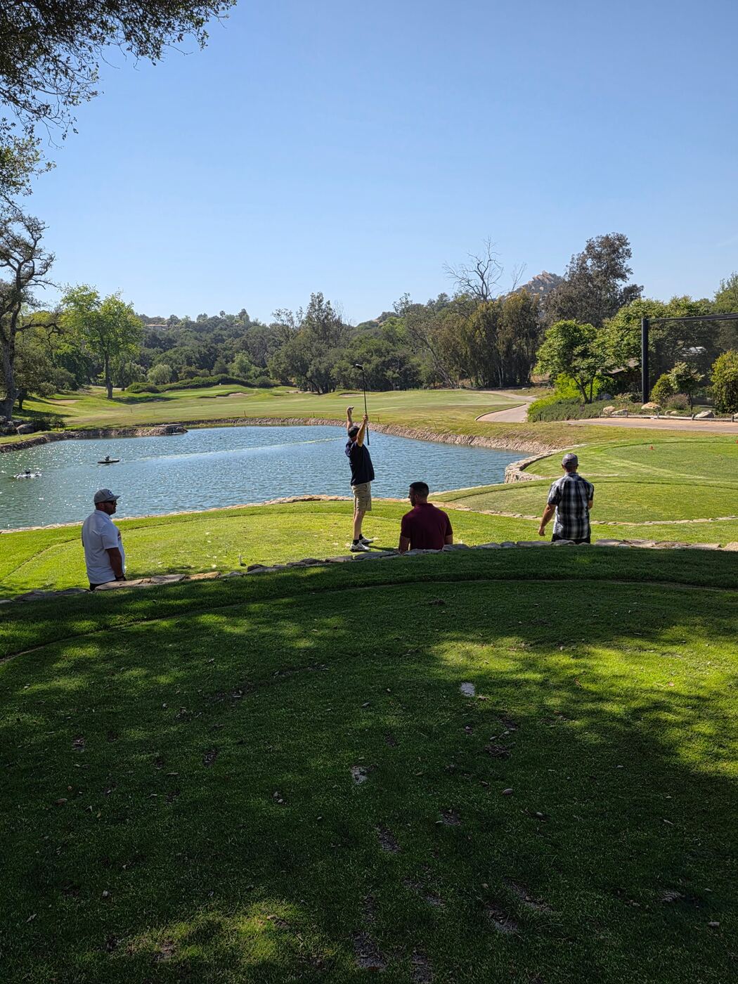 Tee shot over the lake — three brothers watching the line