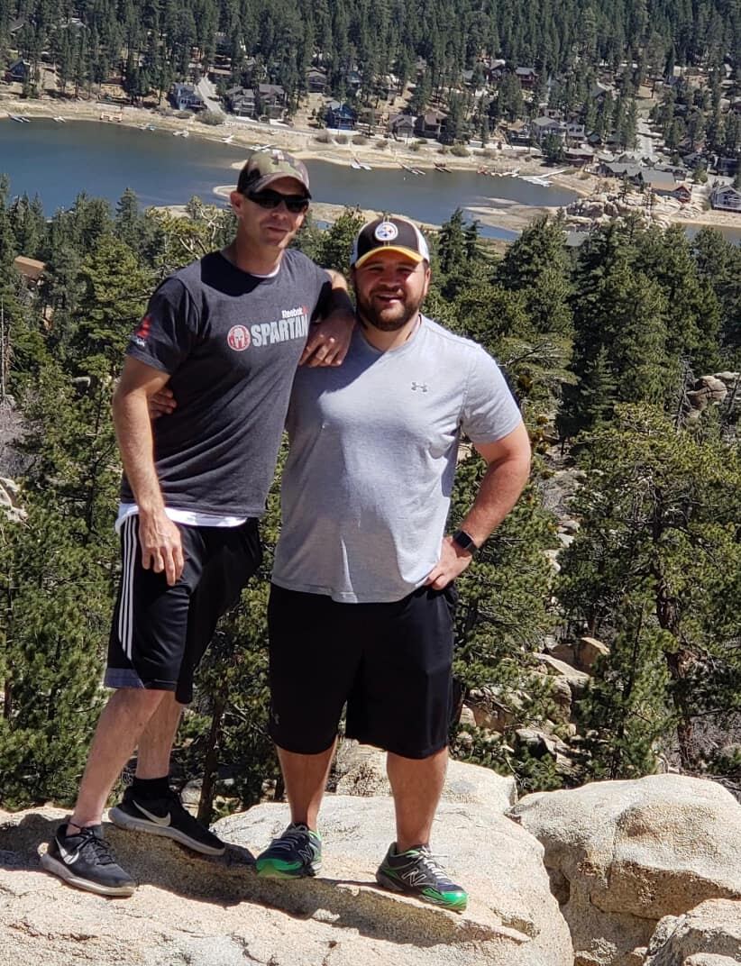Brothers arm-in-arm, calling out the lake below
